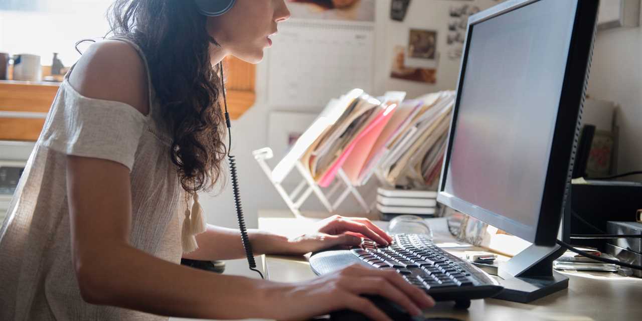 woman with headphones using PC desktop computer