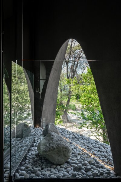 On the ground level, one of the home’s massive cutouts creates a connection with the outdoors.