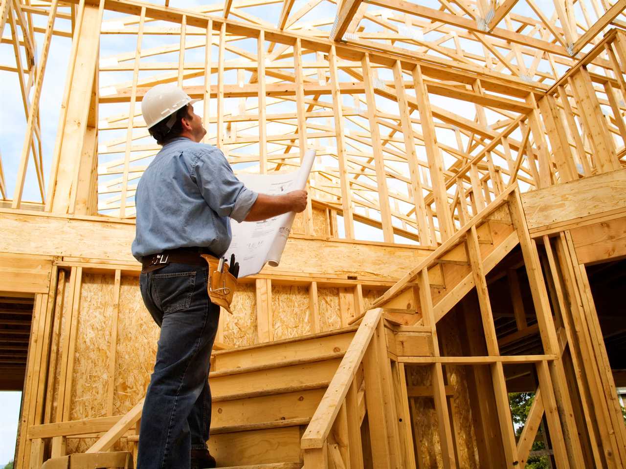 Construction worker observing a house.