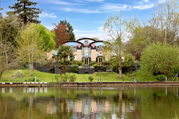 Though enclosed by mature trees, the home still makes a bold statement from the river thanks to its vibrantly designed exterior. Additionally, a similar color palette awaits inside.