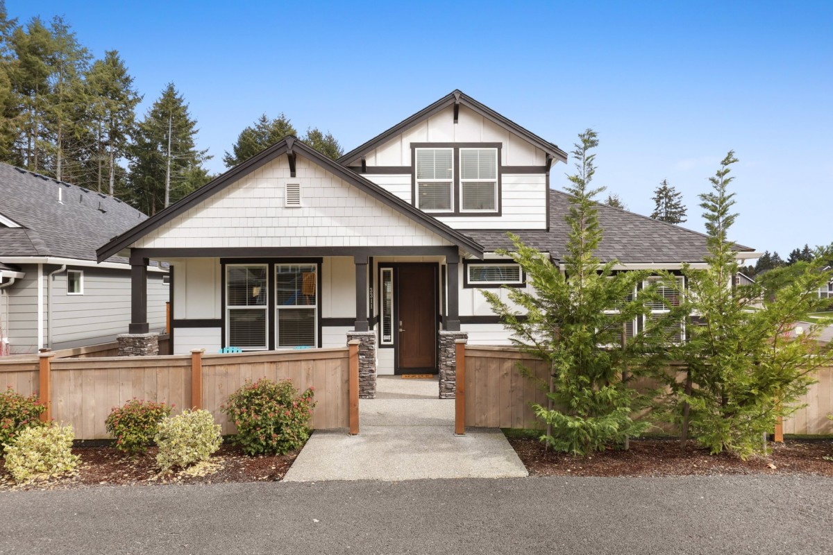 modern cottage with white exterior, stone details and extra half story