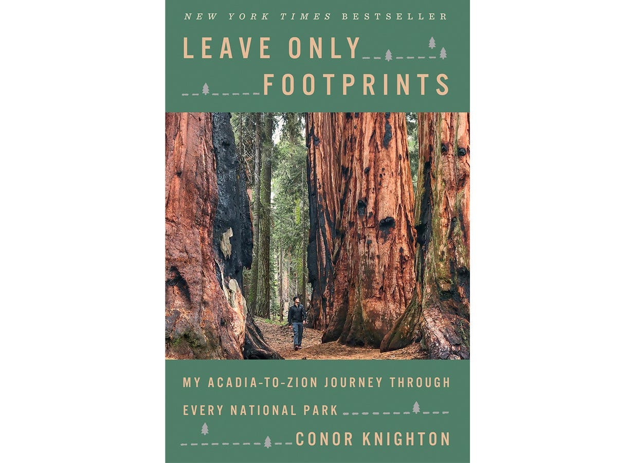 Book cover of "Leave Only Footprints: My Acadia-to-Zion Journey Through Every National Park" by Conor Knighton with and image of the author walking through a redwood forest