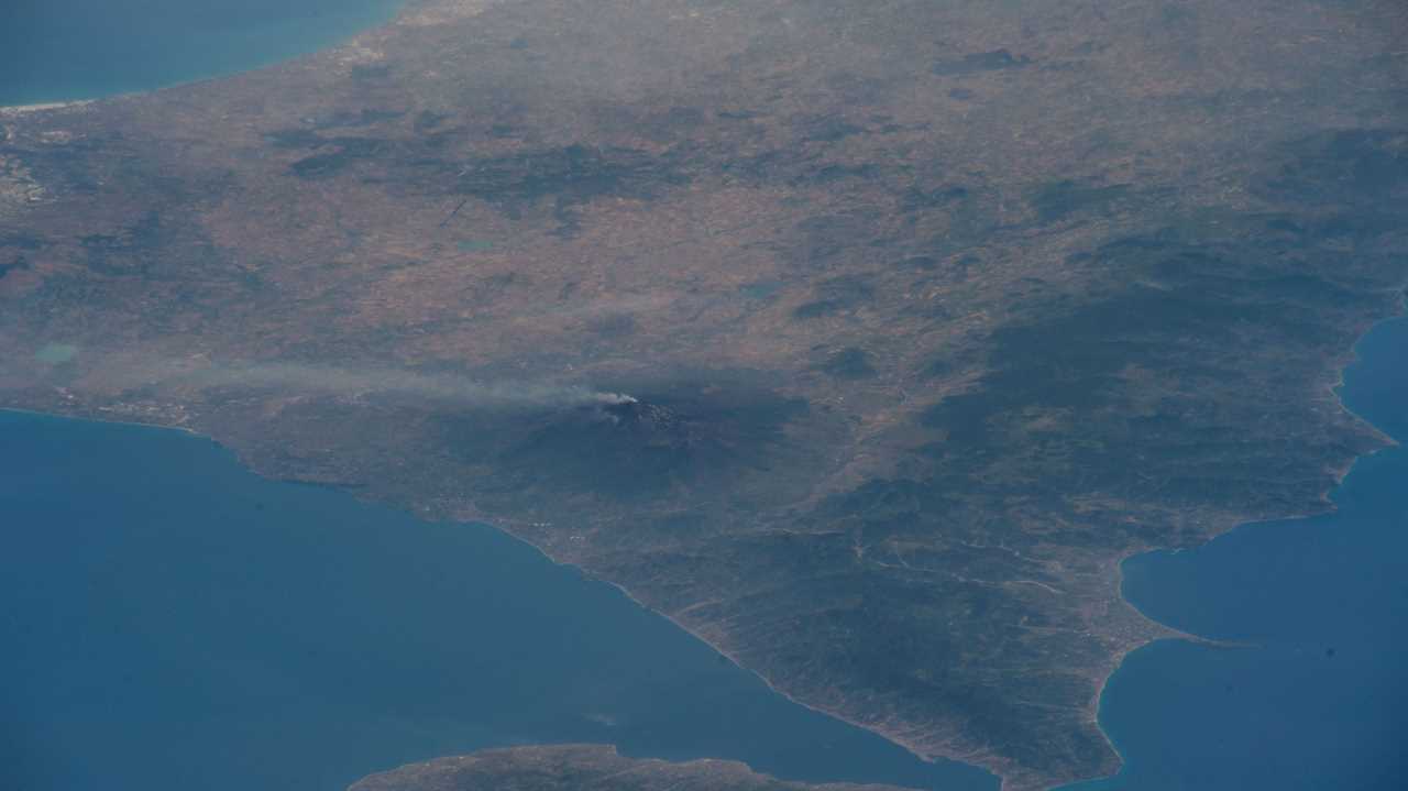 view from space mount etna volcano with steam billowing out