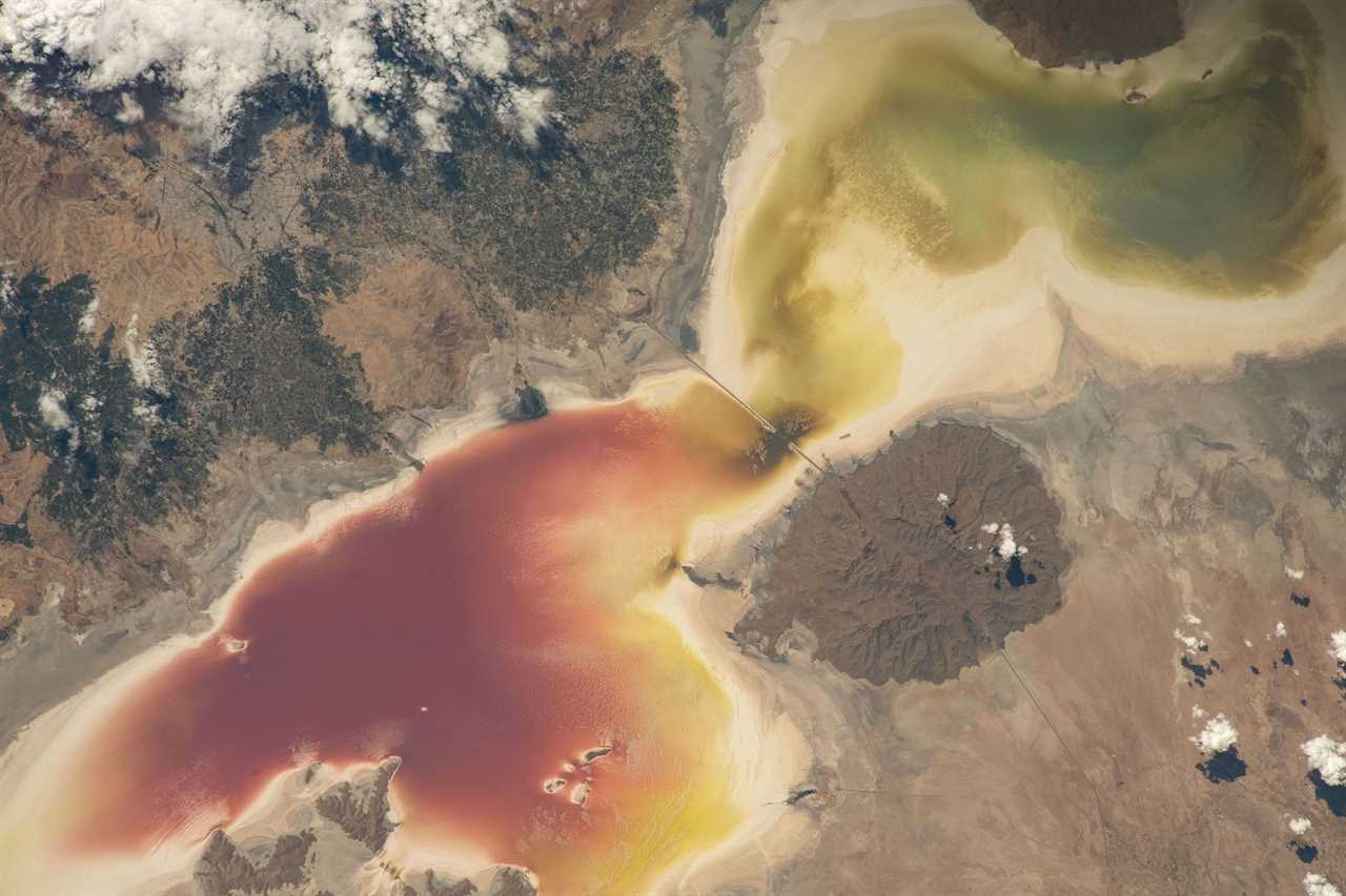 butterfly shaped red and yellow lake in brown rocky landscape