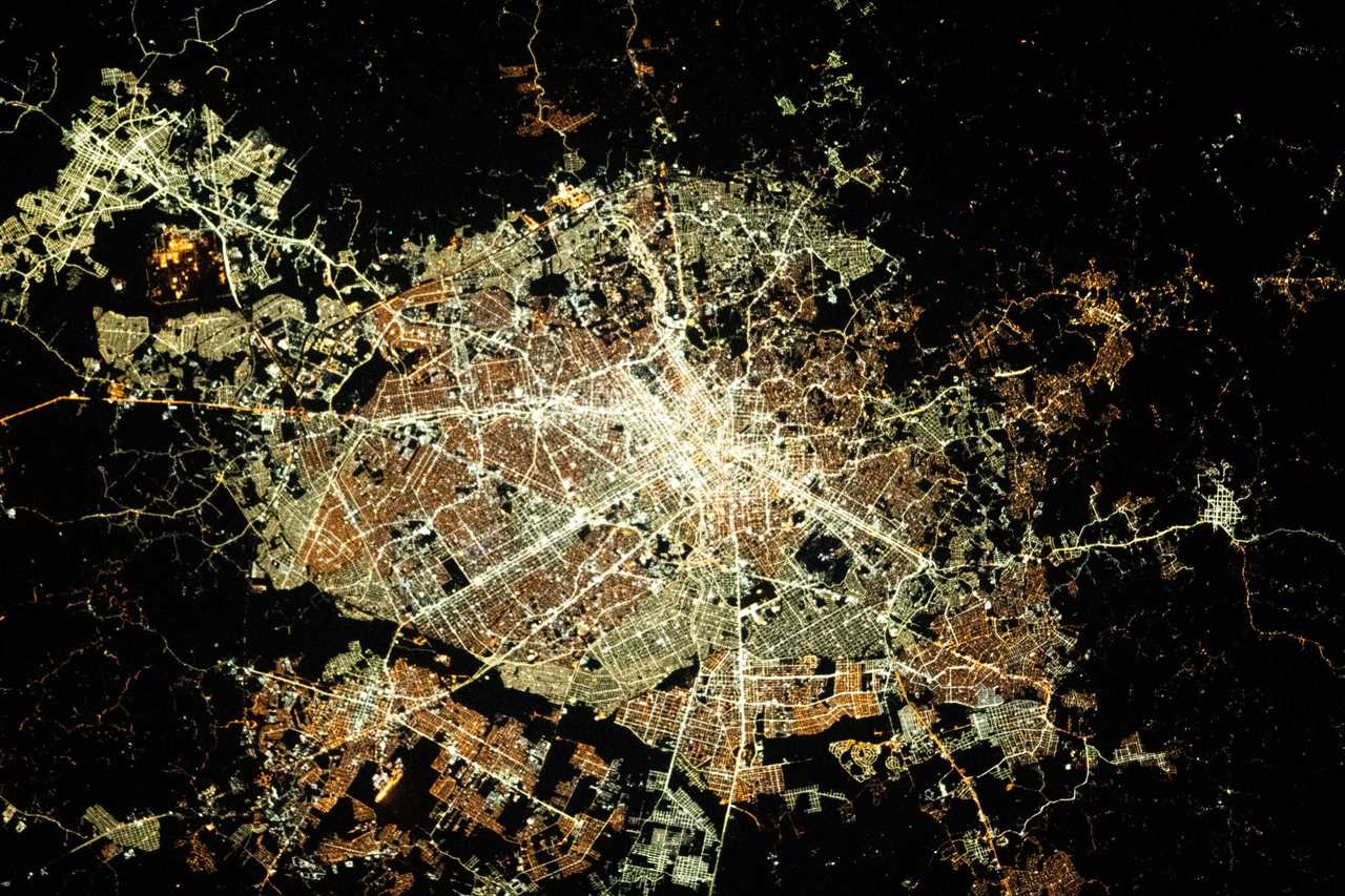 circular city lit up at night view from space