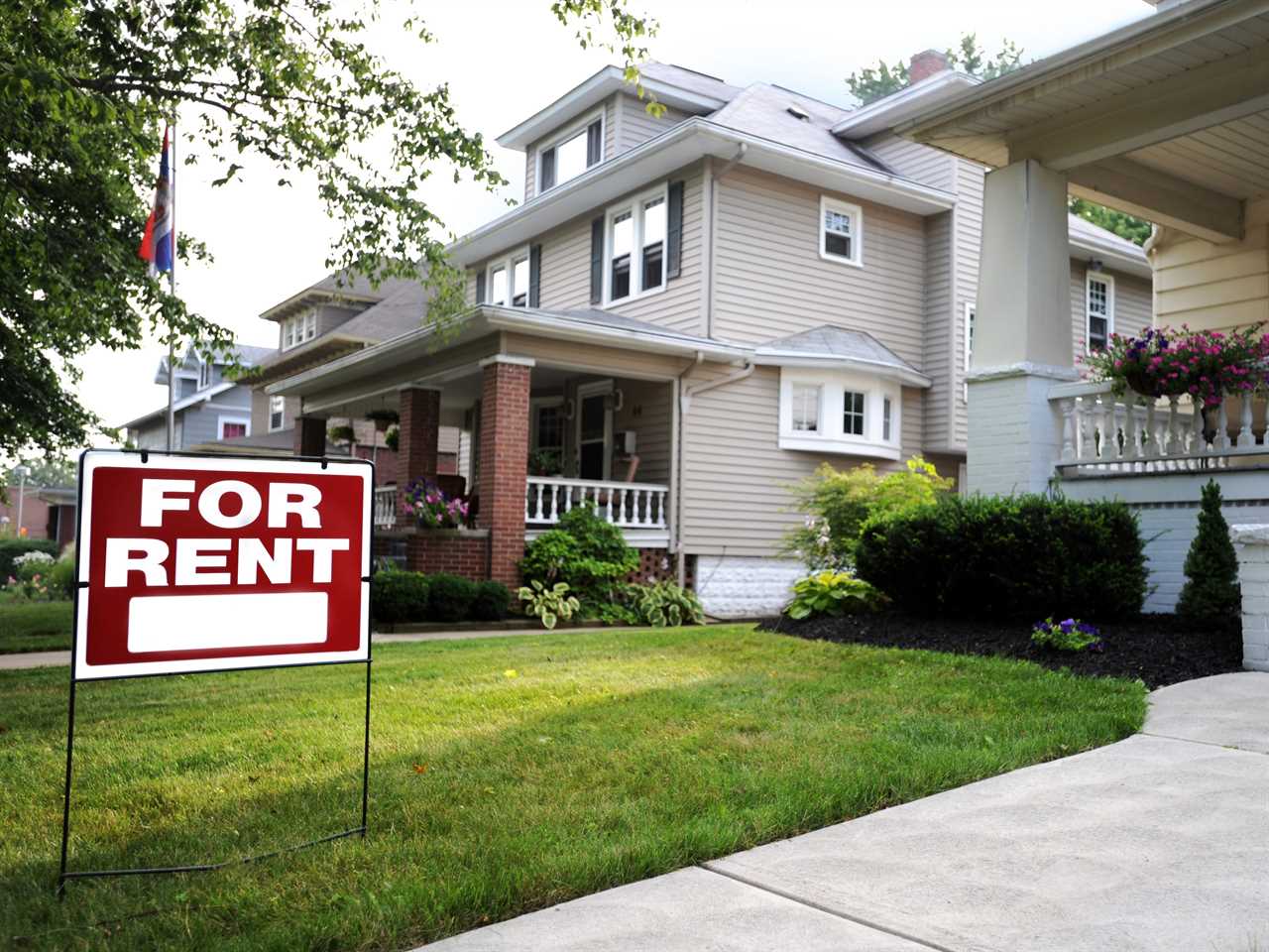 A for-rent sign in front of a suburban house in the US