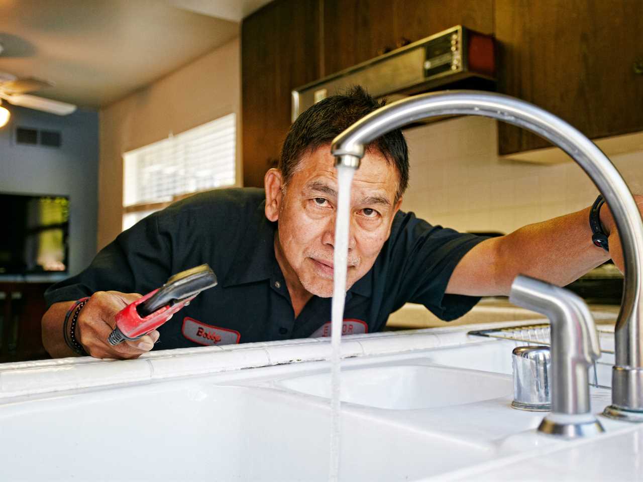 Photo of repair man fixing a sink