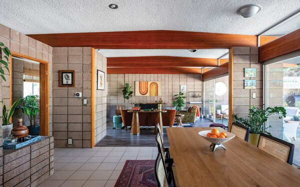 Refinished wood beams anchors the main living areas, complementing the surrounding block walls and floor-to-ceiling glazing that spans across the entire rear of the property.