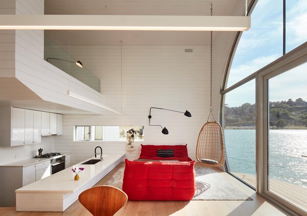 Hanna’s bedroom loft floats above the kitchen’s Caesarstone countertop. Serge Mouille sconces complement linear Pure Edge Lighting pendants. Next to the kitchen, and not visible, are the pantry, laundry, and two spare bedrooms and bathrooms arranged around the front garden.