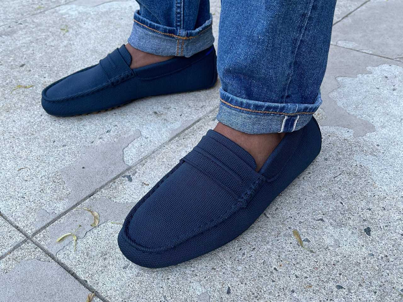 A pair of feet wearing Rothy's loafers.