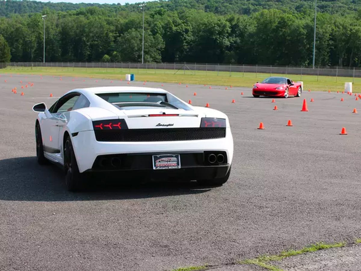 A parking lot with a Lamborghini and some traffic cones.