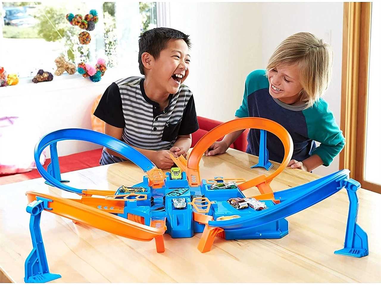 Two children playing with the Hot Wheels Criss Cross Crash Track Set.