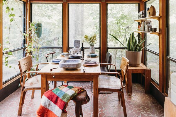 A handmade blanket lies across a vintage stool while granite bookends of his own design and an old-school radio sit atop open shelves above.