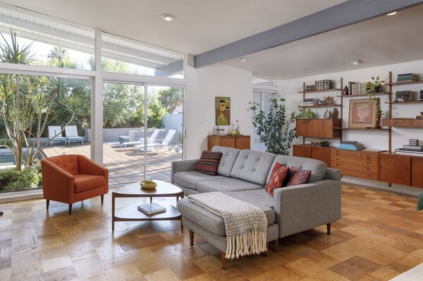 Floor-to-ceiling glazing spans across the rear of the home, allowing the open floor plan to be bathed in natural light while also providing direct access to the lush backyard garden.