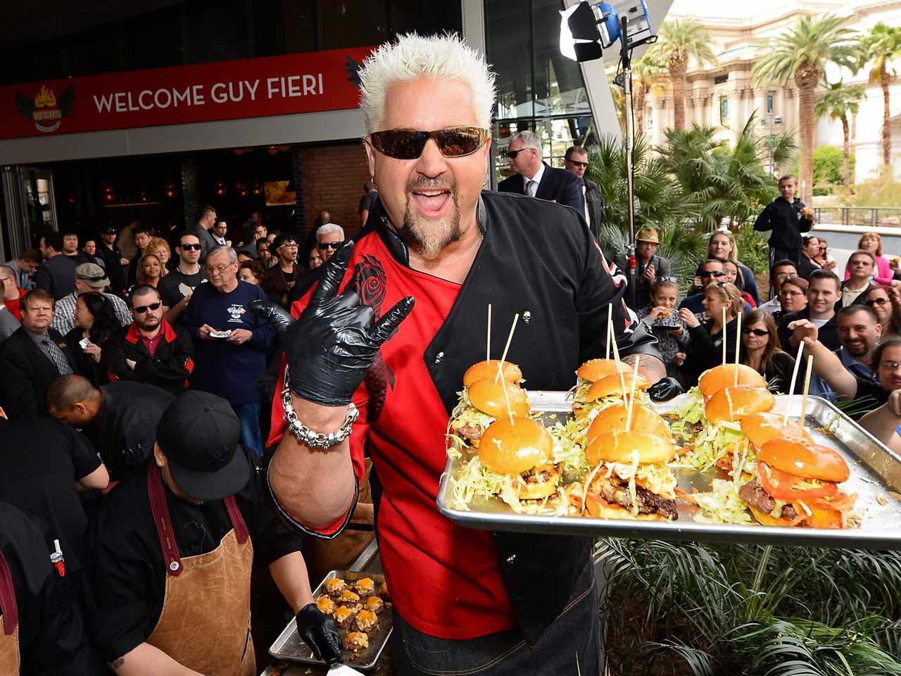 guy fieri holding hamburgers on a tray