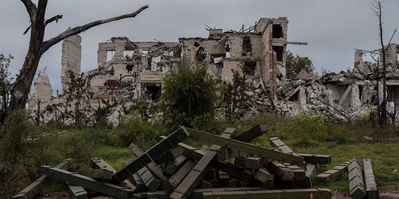 Ammunition boxes lay outside a destroyed school on the outskirts of a recently liberated village outskirts of Kherson, in southern Ukraine, Wednesday, Nov. 16, 2022.