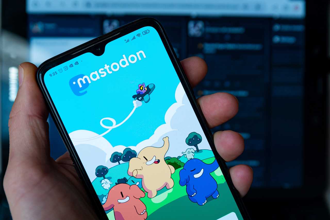 In this photo illustration, Mastodon homepage is seen displayed on a mobile phone screen held by hand. It has been reported that more than 200,000 new users flocked the social media app after the takeover of Twitter by Elon Musk.