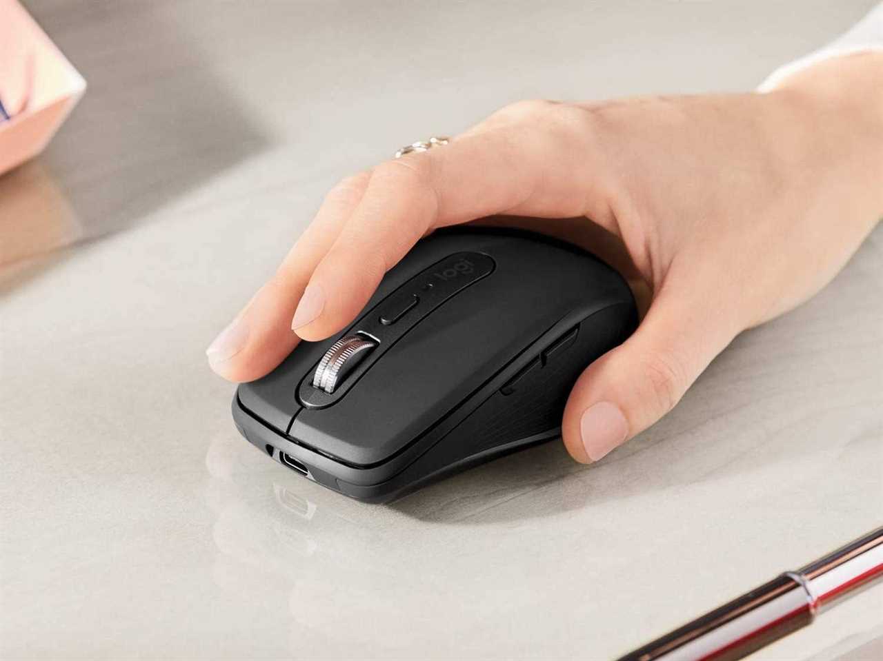 A hand using the Logitech MX Anywhere 3 mouse.