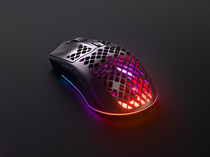 The SteelSeries Aerox 3 Wireless computer mouse sitting on a black surface.