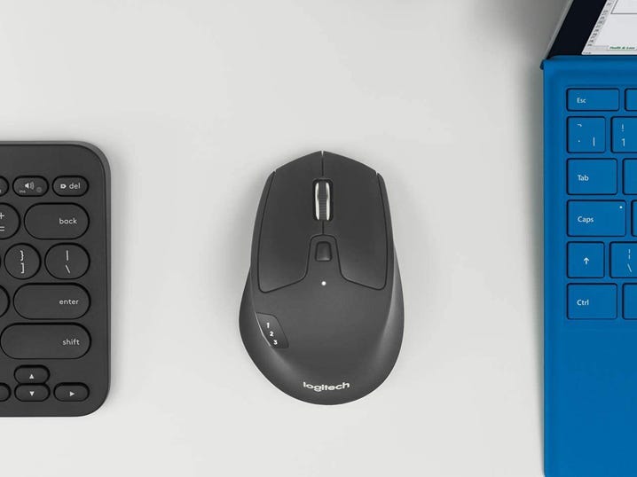 The Logitech M720 Triathlon computer mouse between two different computing devices.