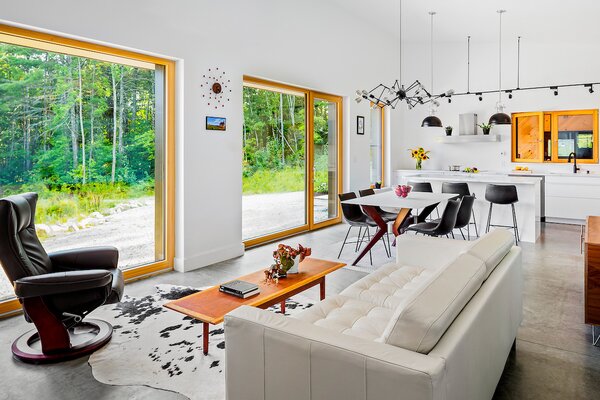 The main living area embraces a monochromatic palette, softened with wood accents. Jenn Fortin found the faux cow hide rug and sofa at IKEA and the spider-like chandelier on Wayfair. The black leather chair is from Jordan’s Furniture and the geometric dining table is by Canadel (made in Canada). 