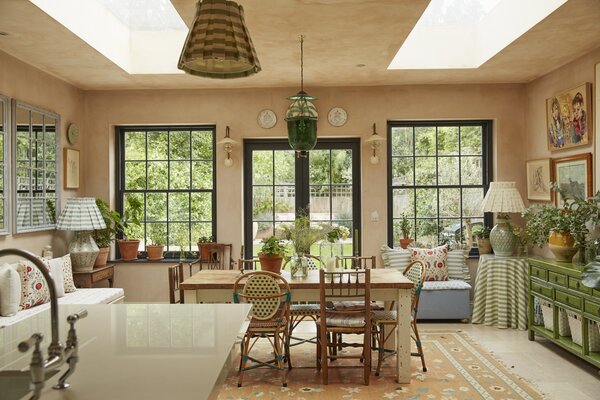 The main living areas are located at the back of house, where ample natural light filters through two large skylights, sash windows, and French doors leading to the garden.