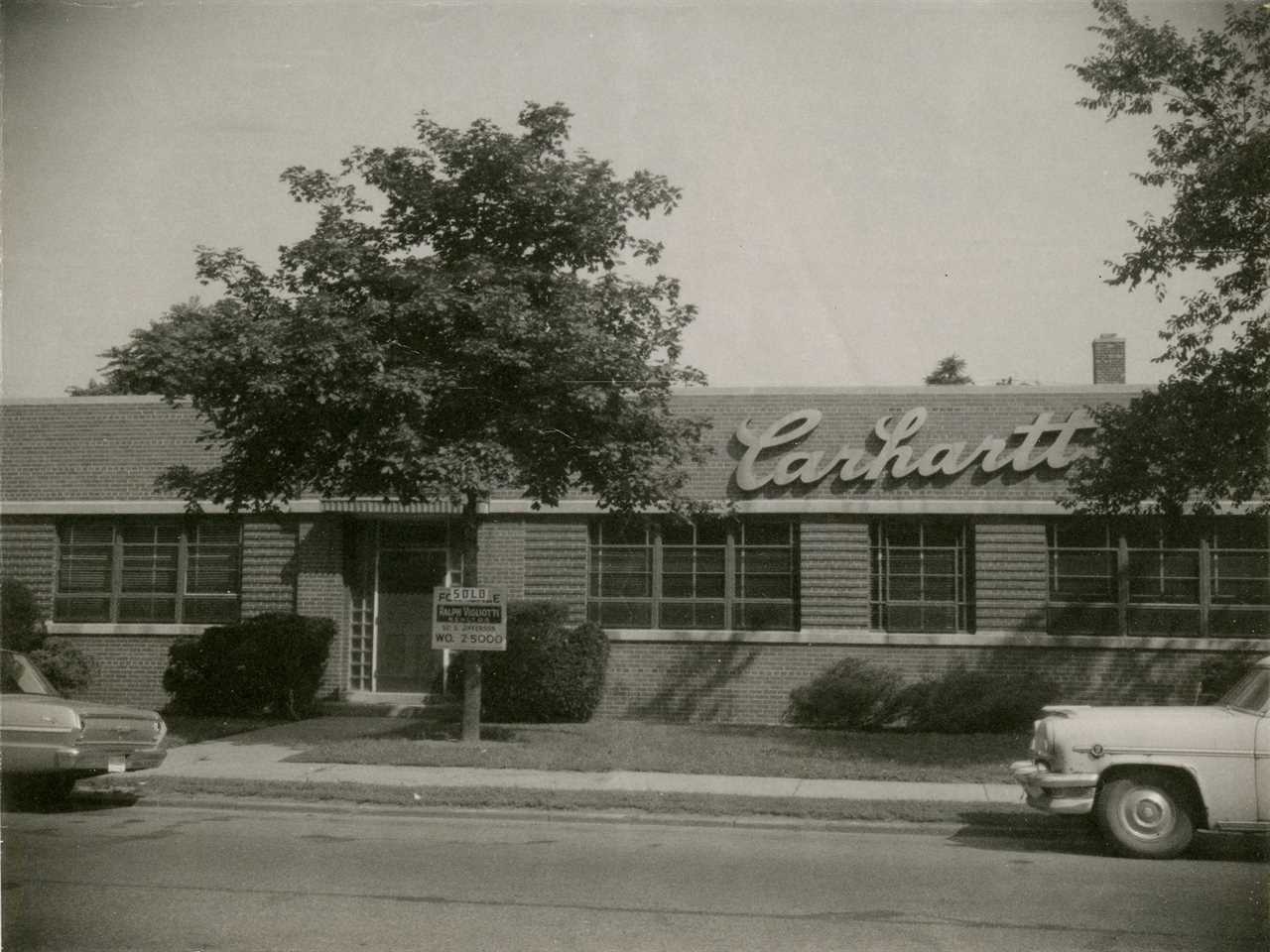 Black and white photo of Carhartt headquarters with two cars outside