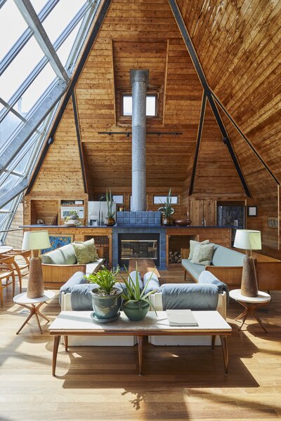 The home's upper level frames picturesque views of Fire Island's National Seashore. An original blue-tiled fireplace serves as a subtle partition between the living room and kitchen.