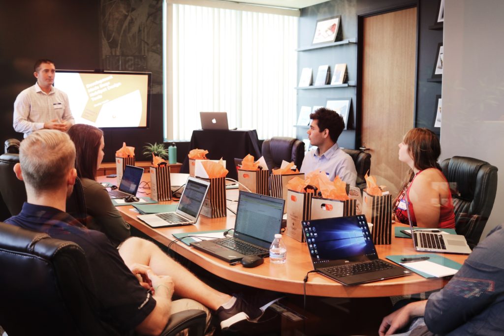 A group of people sitting around a large boardroom table.