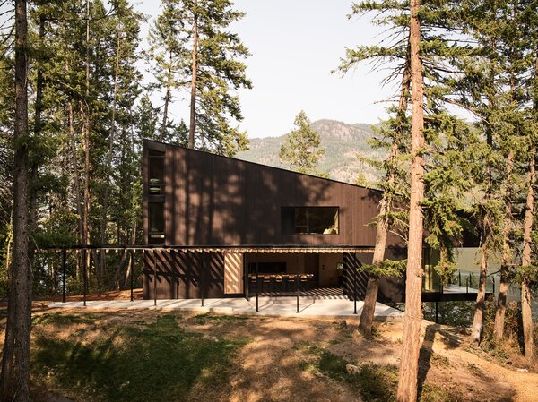 The cabin’s exterior is clad in dark-stained western red cedar and fiber cement panels, and its cantilevered deck provides panoramic views.