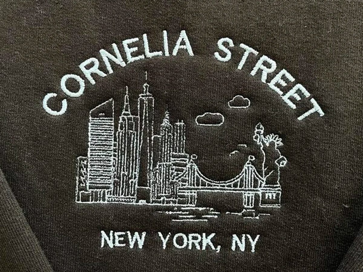 Embroiderry of Cornelia Street, Taylor Swift’s iconic former New York City apartment, on a dark green sweatshirt.