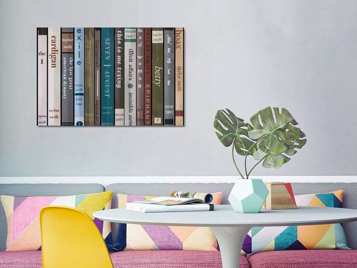 Songs of Taylor Swift's album "Folklore" made into canvas art where each song is shown on the spine of a book hung on a living room wall