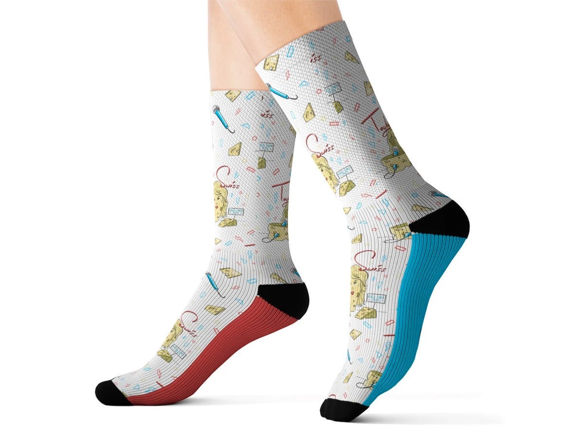 Person's feet walking while wearing "Taylor Swiss" socks, with a punny design combining Taylor Swift with Swiss cheese.