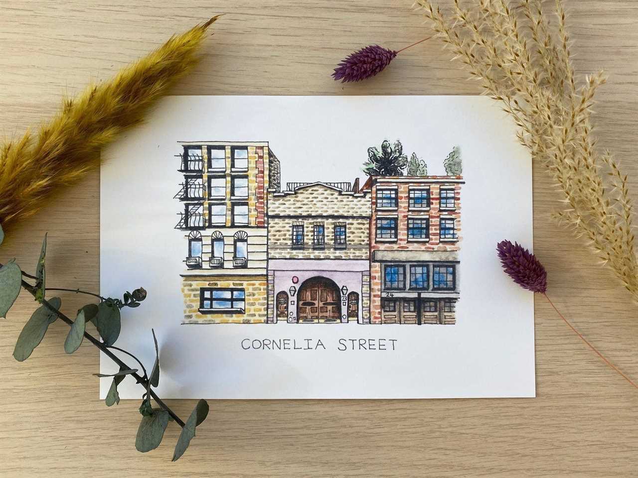 A drawing of Taylor Swift's former Cornelia Street apartment from Etsy set on a tabletop surrounded by dried plants, one of the best gifts for a Taylor Swift fan