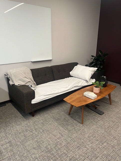 A sofa turned into a bed with a coffee table next to it.