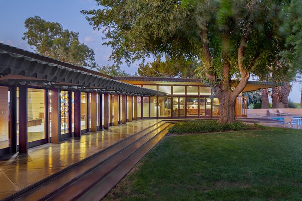 The expansive home features an L-shaped wall of windows allowing view over the backyard lawn and pool from the living areas.