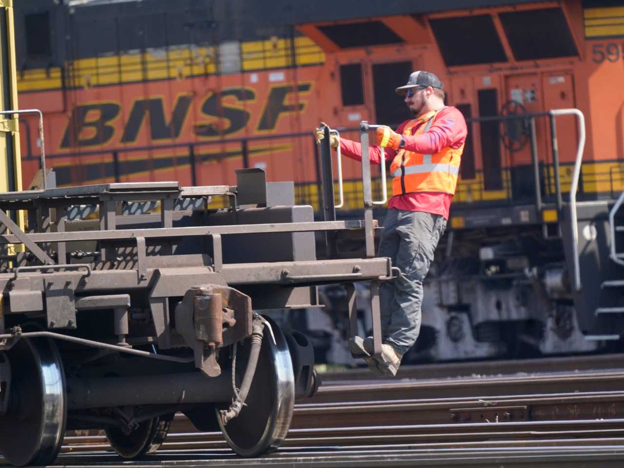 A worker rides a rail car at a BNSF rail crossing in Saginaw, Texas, Wednesday, Sept. 14, 2022. Most railroad workers weren't surprised that Congress intervened this week to block a railroad strike, but they were disappointed because they say the deals lawmakers imposed didn't do enough to address their quality of life concerns about demanding schedules and the lack of paid sick time.