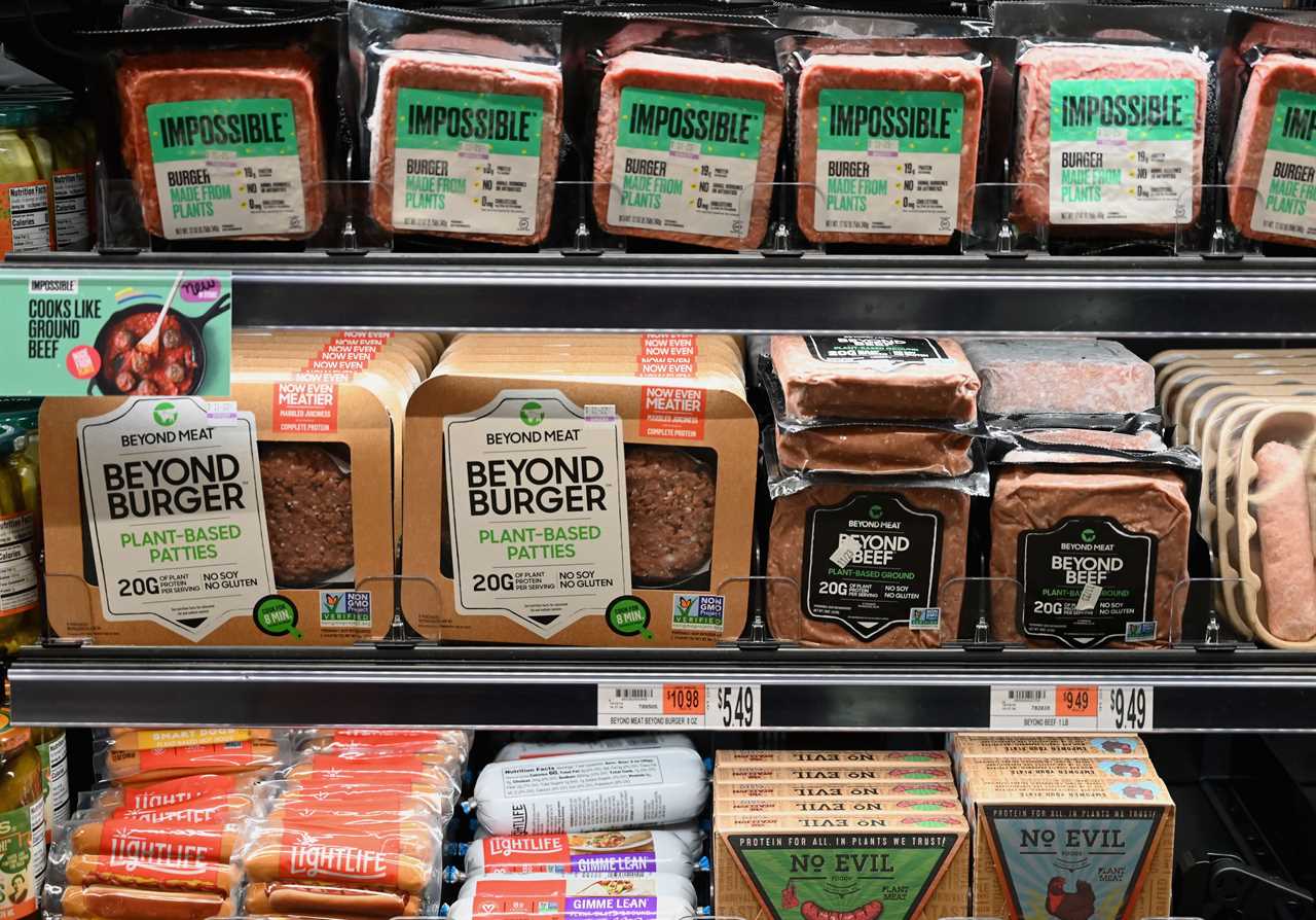 Packages of Beyond Meat products sit below Impossible Foods plant-based ground beef in a grocery store cooler case in New York City.