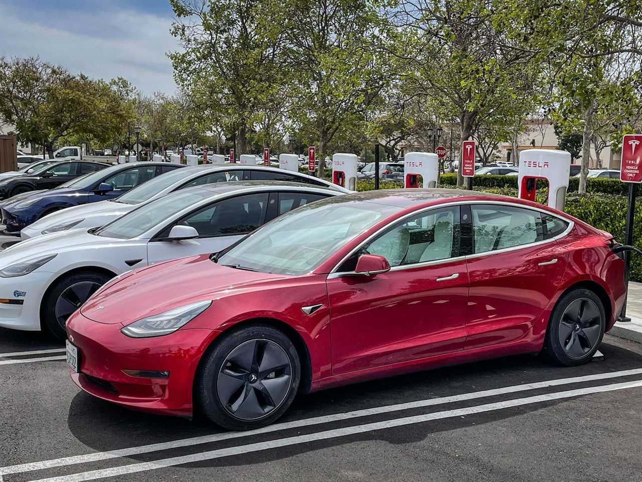 Tesla electric cars charge at a Supercharger.