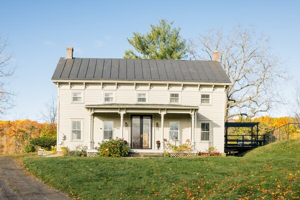 A long, winding driveway leads to the two-story farmhouse, set on a spacious 1.2-acre lot.