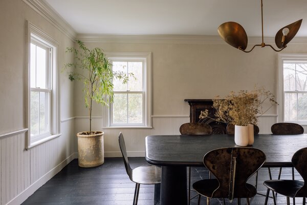 Original details are displayed immediately upon entry, including the moldings wrapping around the main dining area, as well as the wide-plank floors and decorative mantle.