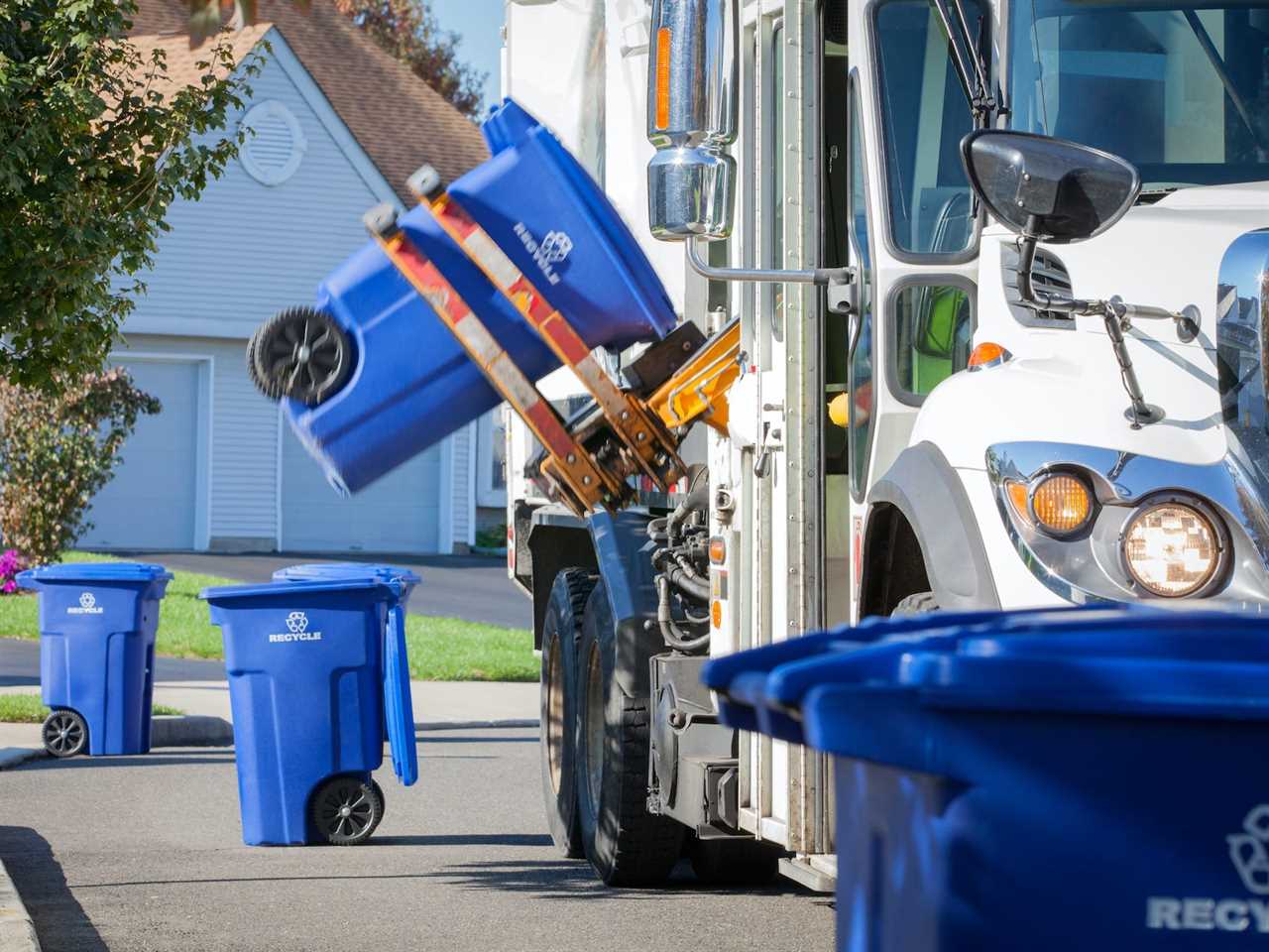 A recycling truck lifting up container