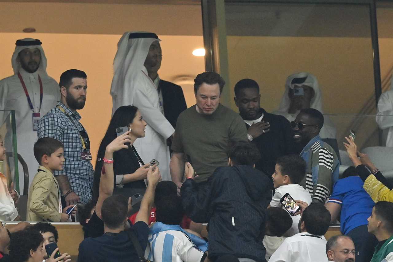 Elon Musk takes photos with fans during the World Cup final in Qatar.