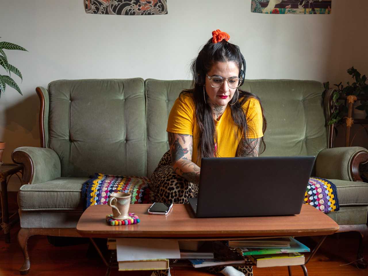 Woman sitting on a couch types on a laptop