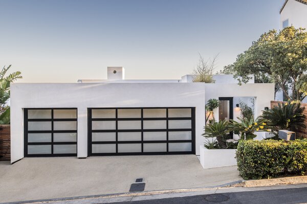 The 1980s home, which appears to be only one level from street view, was fully renovated and now sports a sleek white-and-black facade. Its bluff location offers ample privacy.