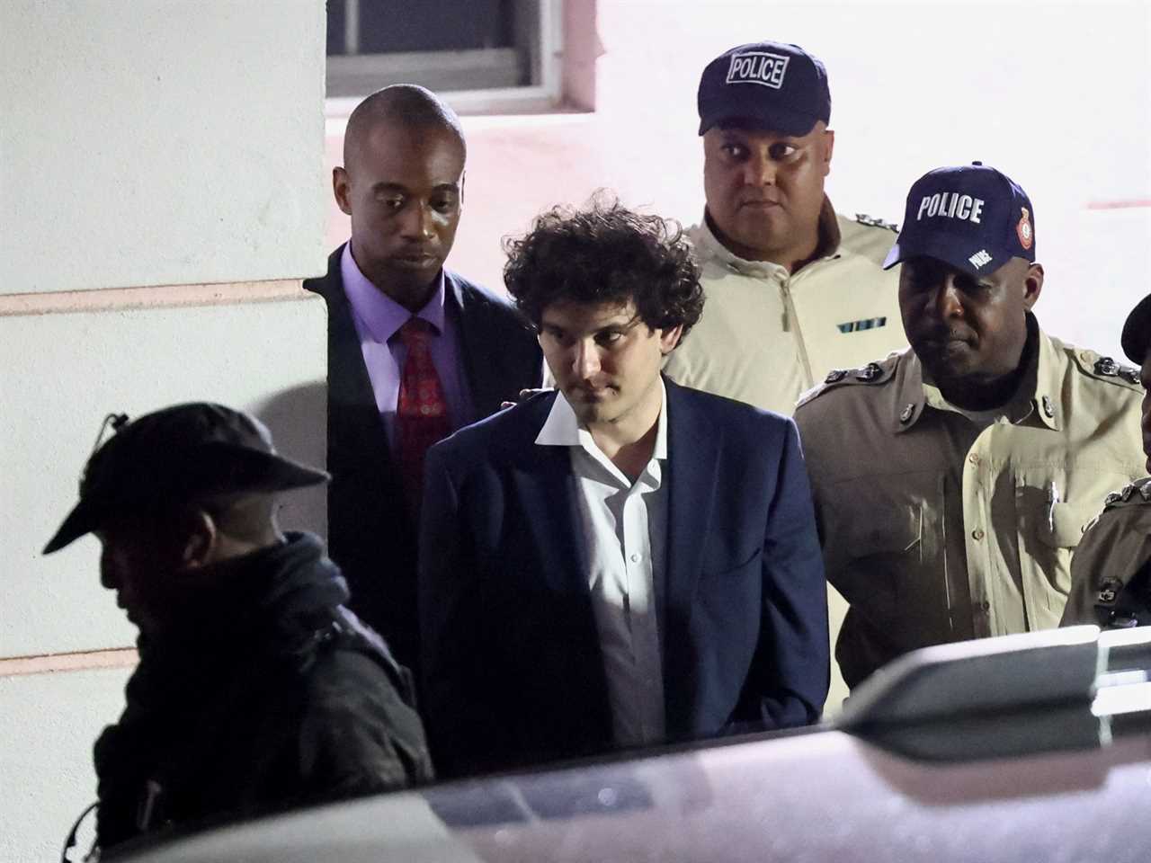 Sam Bankman-Fried is escorted out of the Magistrate Court building after his arrest, in Nassau, Bahamas December 13, 2022.