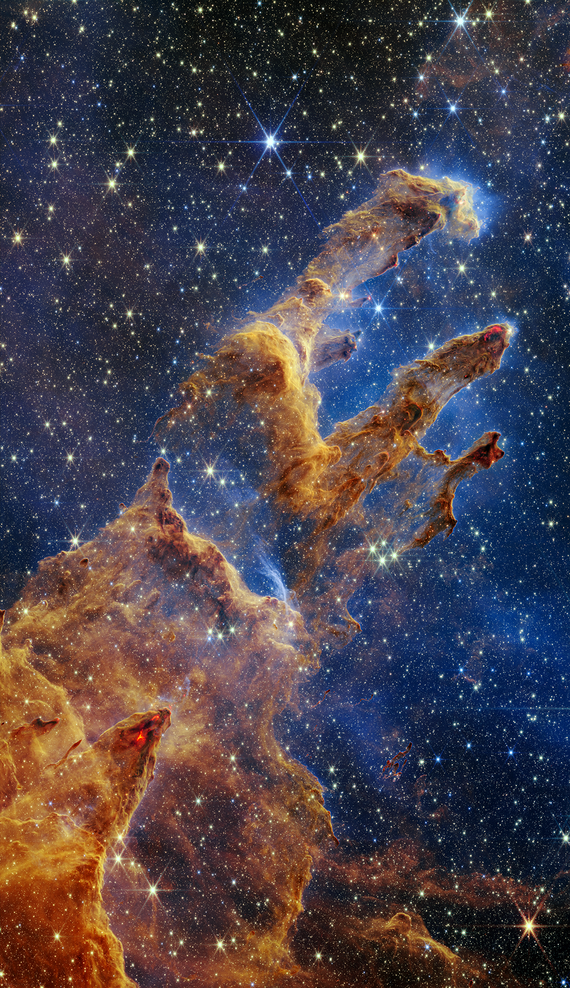 The Pillars of Creation are set off in a kaleidoscope of color in NASA’s James Webb Space Telescope’s near-infrared-light view. The pillars look like arches and spires rising out of a desert landscape, but are filled with semi-transparent gas and dust, and ever changing. This is a region where young stars are forming - or have barely burst from their dusty cocoons as they continue to form.