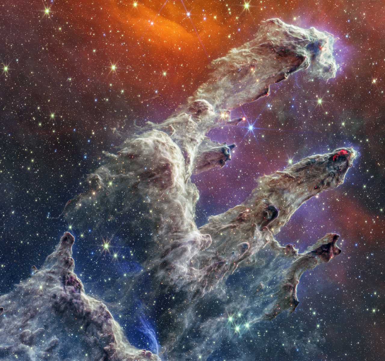 pillars of creation spires of grey dusts with purple orange space background full of stars