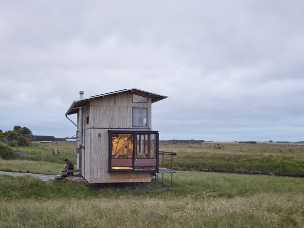 The compact house is sheathed in cypress, glass, and copper and features an expandable roof.