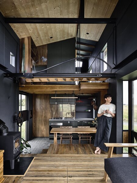 Salvaged ironbark floors in the living room step down to the adjacent kitchen and dining space, creating a built-in seating area.